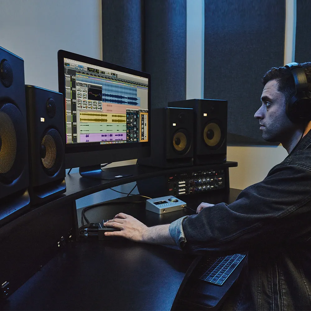 Estudio de grabación profesional equipado con monitores de estudio, interfaz de audio y micrófono de condensador.